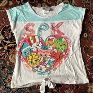 White and blue shopkins tee shirt with knot tie on bottom